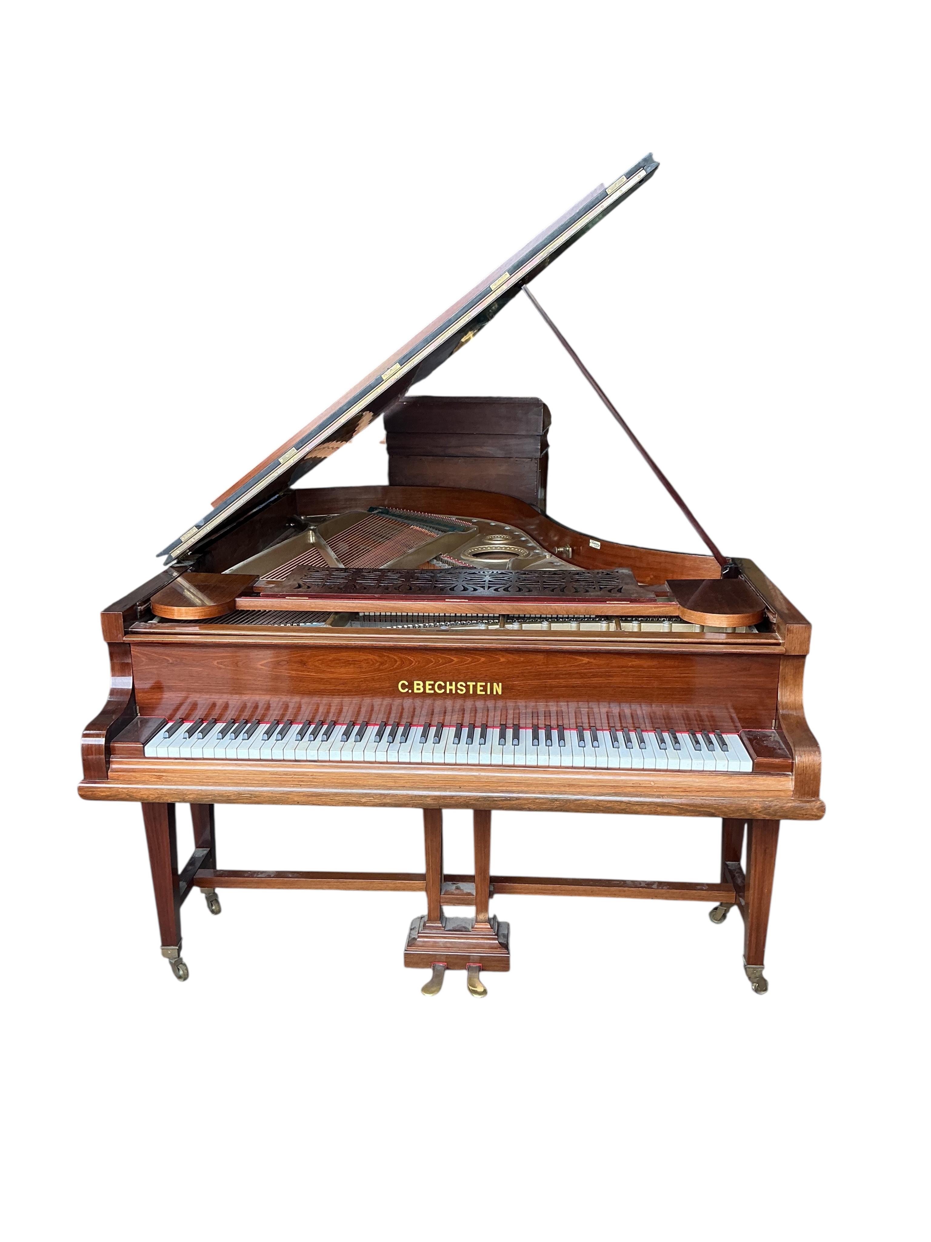 An early 20th century Bechstein 6ft. 8in. rosewood grand piano retailed by Harrods and duet piano stool